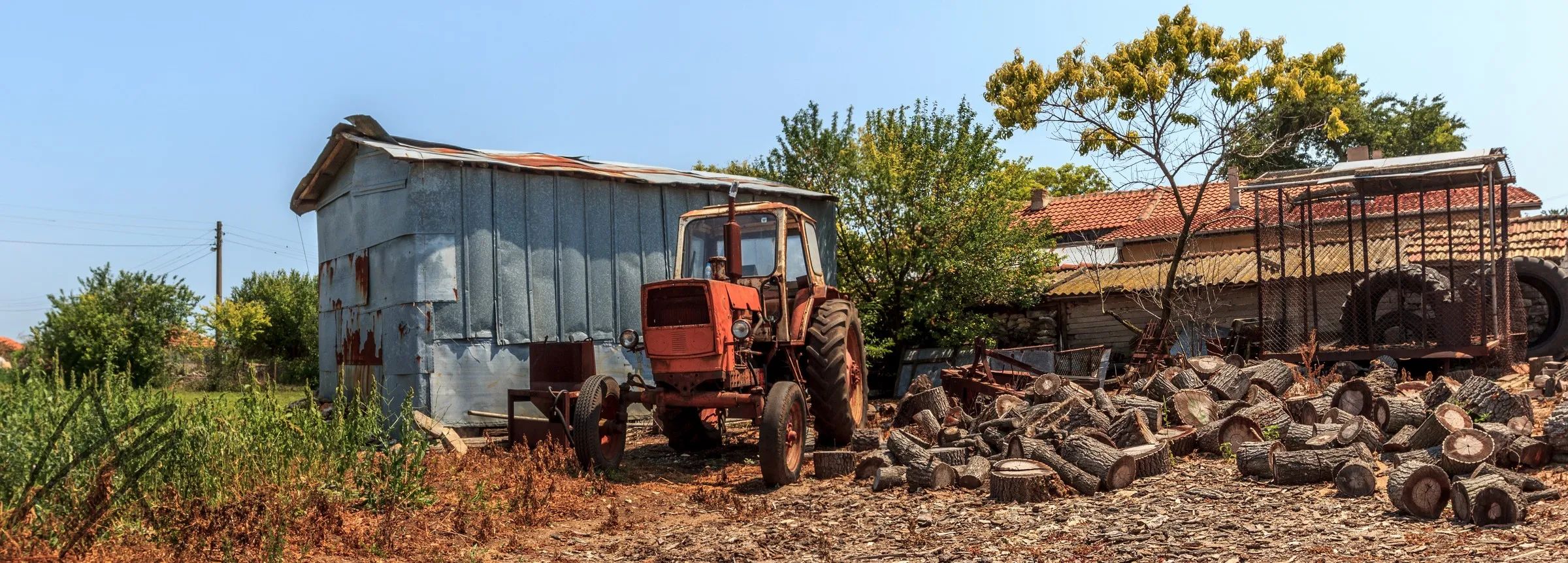 Tractor and woodpile, farmyard